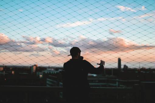 cadena valla de tela metálica puesta de sol cielo nubes chico hombre
