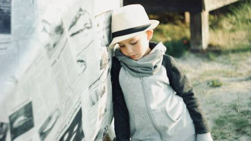 pensive young  child  thinking  pensive  hat  newspaper  beach