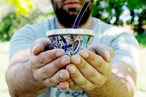 offering Adult man offering yerba mate drink