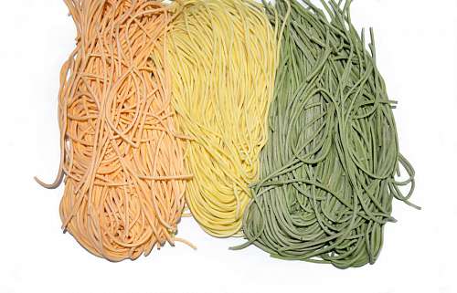 rolling-up-sleeves Colourful Italian pasta tagliatelle on white background
