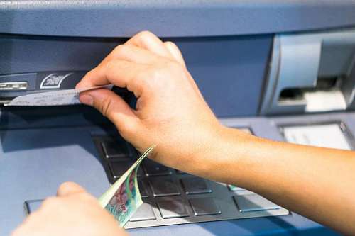 Female hand holding a receipt obtained from the ATM after withdrawing cash