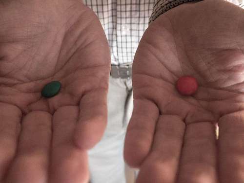Hand with blue and red pills