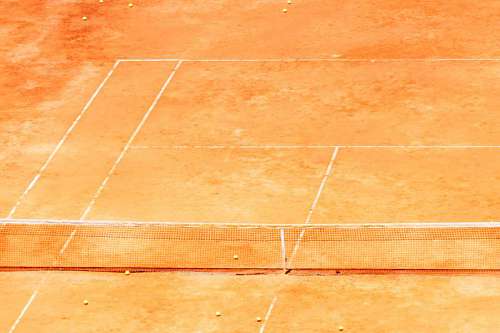 tennis red yellow ball on a clay tennis court orange color