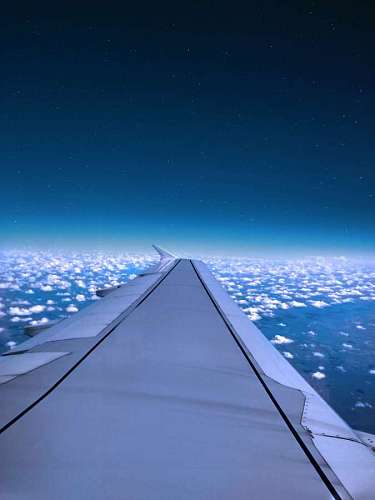 Ala de avión vuela sobre el cielo azul y la nube blanca en el atardecer