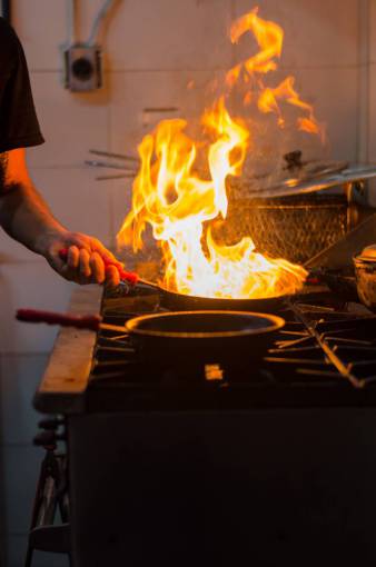preparing-to-work Chef cooking with fire in the pan