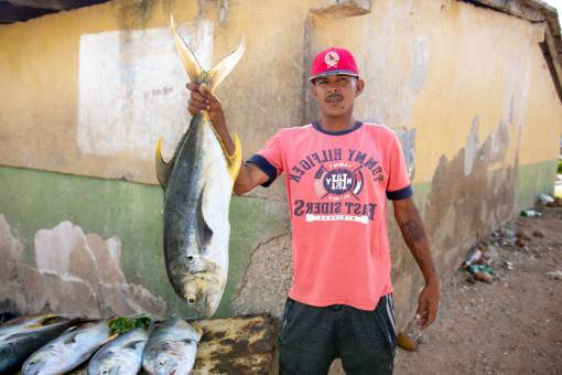 weight-loss Man holding tuna fish for sale in Margarita Island, Venezuela