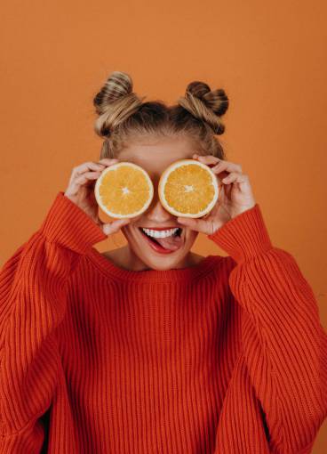 healthy-lifestyle Portrait of young model posing with two halves of oranges in her eyes