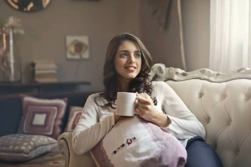 morning Woman with cup of coffee leaning on the couch