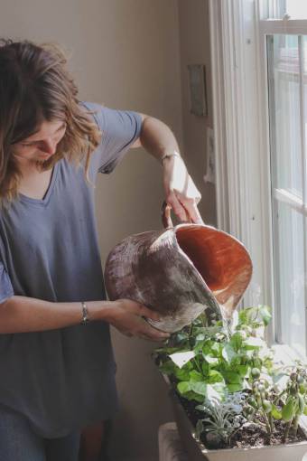 environment Young woman watering plants at home