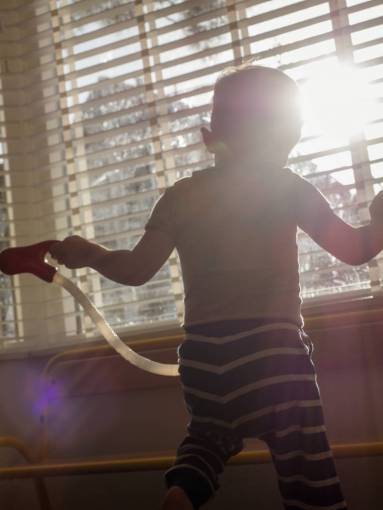 environment Little boy playing at home in front of the window 