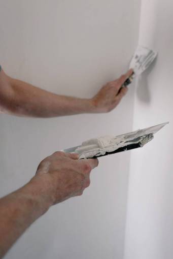 trabajo Pintores aplicando yeso en la pared.