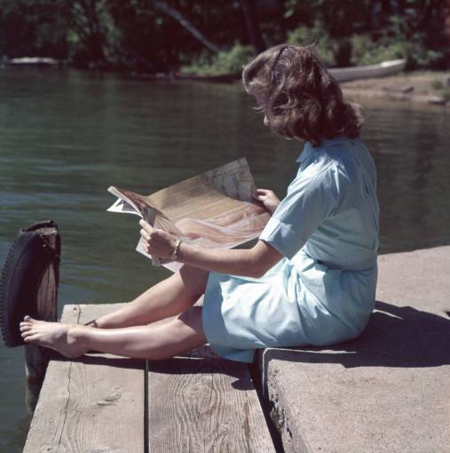 parque Escena vintage de una mujer leyendo una revista junto a un lago