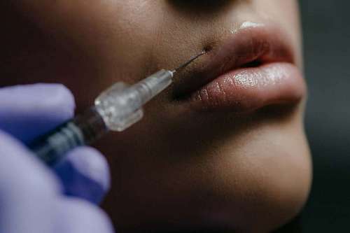 Woman applying botox to her mouth
