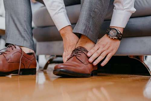 Executive man putting on brown leather shoes
