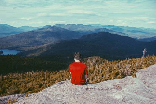 excursionista gente de montaña hombre solo descansar rocas soleado