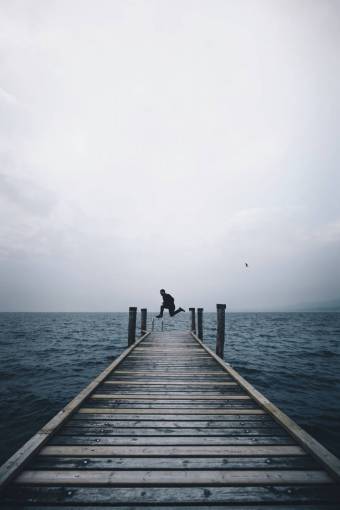 people  man  jump  black and white  bridge  water  ocean