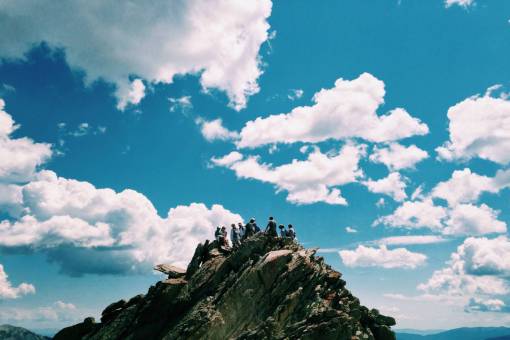 acantilado cielo azul nubes montaña acantilado gente
