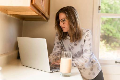 desarrollo mujer de negocios en casa escribiendo vaso de leche bebida