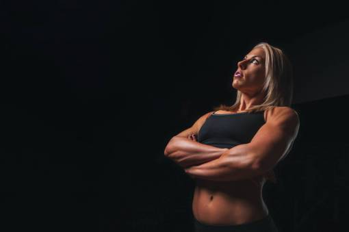 muscular fit woman against black background