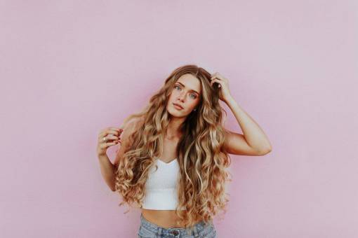 Long hair blonde woman against pink wall