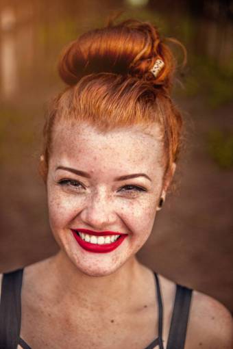 Portrait of a young redhead woman with freckles smiling