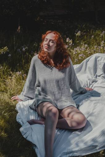 Redhead woman sunbathing in the garden