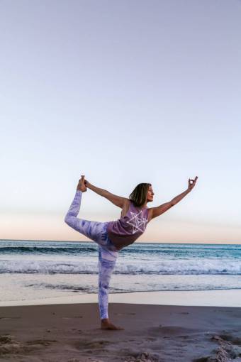 Woman practicing yoga on the beach