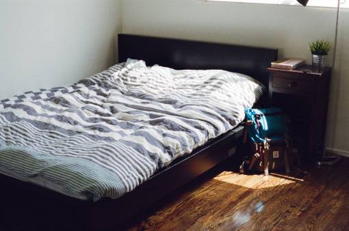 mochila las sábanas del dormitorio cubren la mesita de noche de madera dura