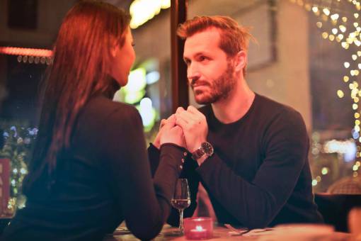 cena romántica pareja tomados de la mano hombre mujer