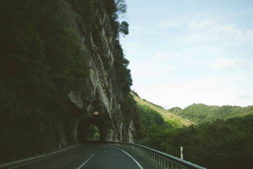 sky  road  tunnel  winding  hills  grass  trees