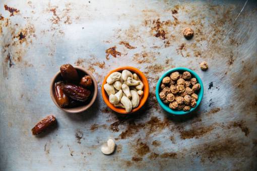 raised cashew  nuts  peanuts  prunes  bowl  raisins  table
