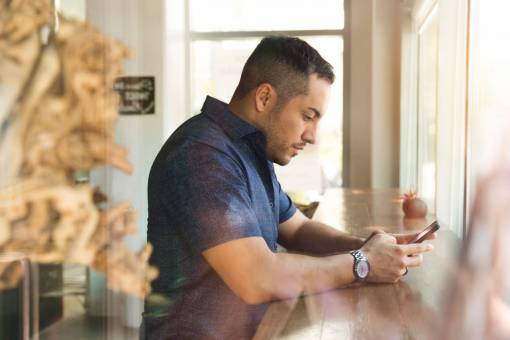 mecanografia hombre café teléfono móvil escribiendo enfoque concentrado escritorio