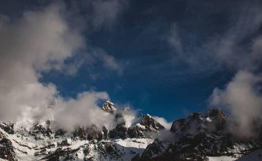 montaña valle nubes cielo azul nieve invierno