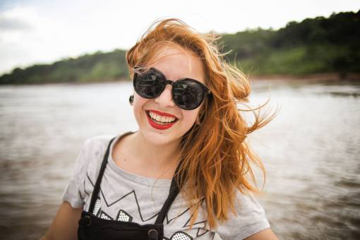 lapiz labial mujer gafas de sol sonriente sonrisa feliz cabello rojo ventoso