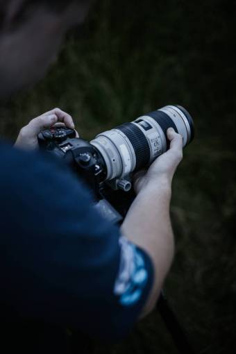 sostener Fotógrafo sosteniendo su cámara,