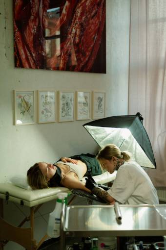 hacer Mujer haciendo un tatuaje