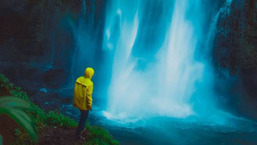waterfall dramática cascada niebla hombre chaqueta amarilla impermeable