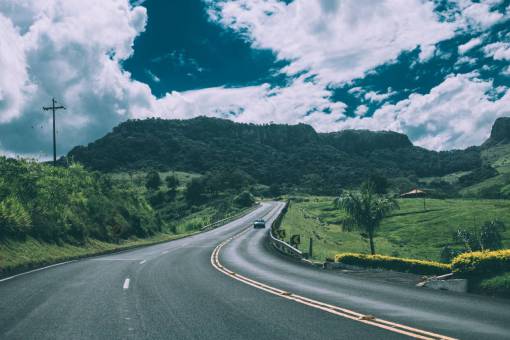 road  highway  cars  driving  green  grass  fields