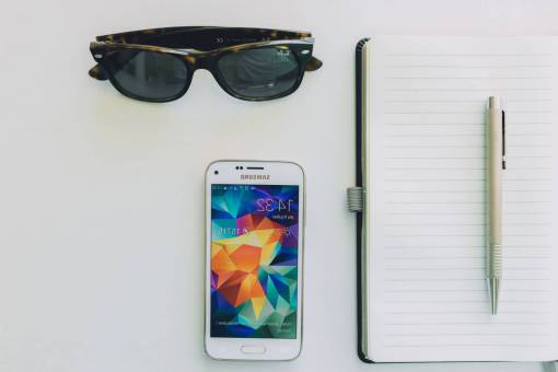 smartphone móvil bloc de notas portátil bolígrafo tecnología gafas de sol