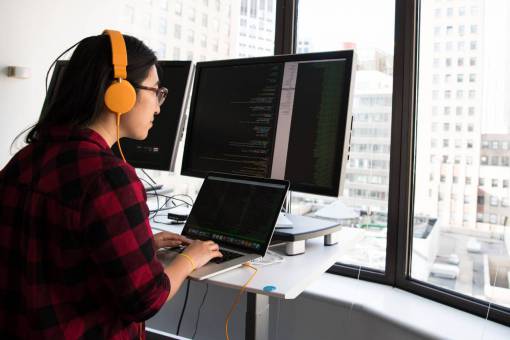desarrollo mujer desarrollador oficina monitor programador de código de doble pantalla