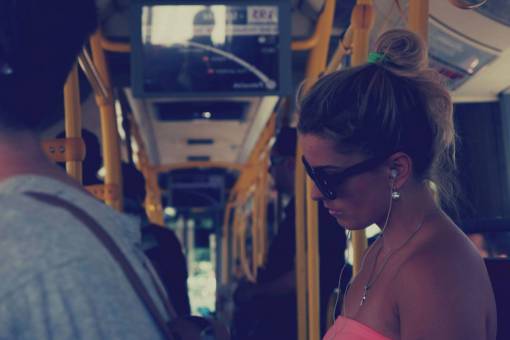 auriculares chica mujer bus transporte gente gafas de sol auriculares