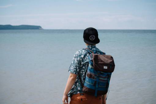 mochila gente hombre solo viajes aventura gorra océano