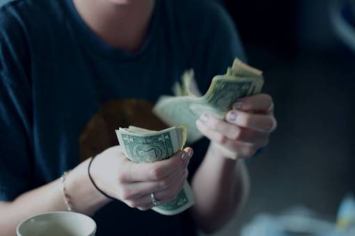 A person counting dollar bills