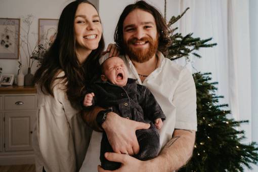 Portrait of a family with their newborn son arriving home