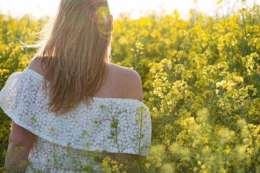 Woman from the back walking in a field of wildflowers