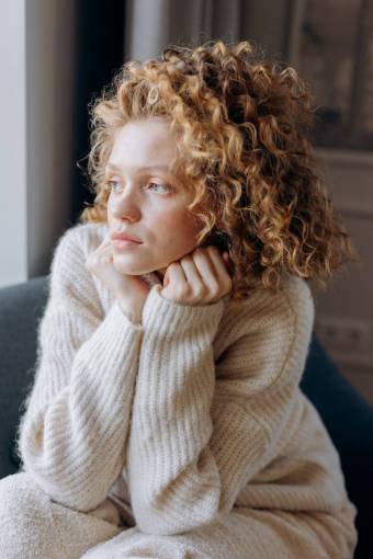 sweater young woman with swatter looking out the window