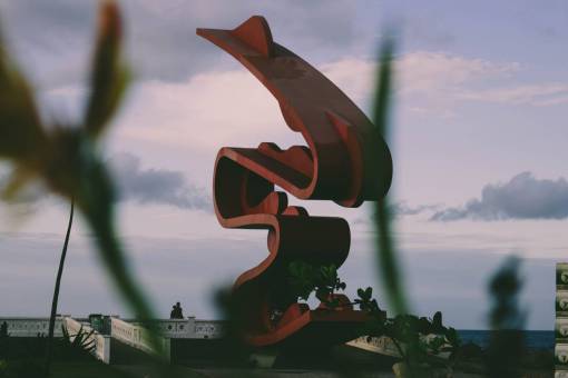escultura arte escultura cielo rojo nubes plantas gente