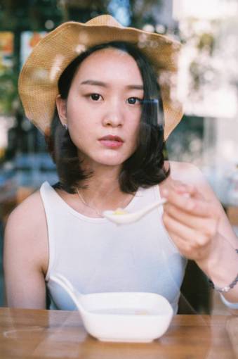 asian-and-indian-ethnicities lifestyles one person young adult asian;woman;eating;ramen;glass women adult caucasian ethnicity