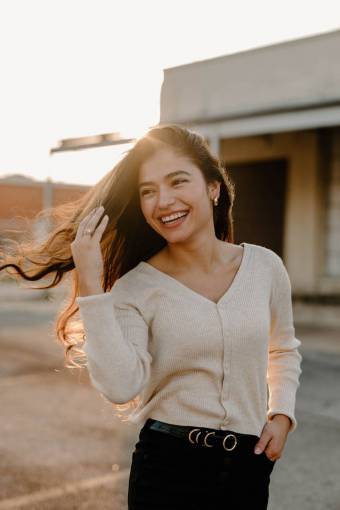 one person young adult latin woman;25 years old;sunset;hair;wind adult women smiling outdoors
