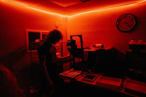 blanco Fotógrafo que revela fotografías en un cuarto oscuro